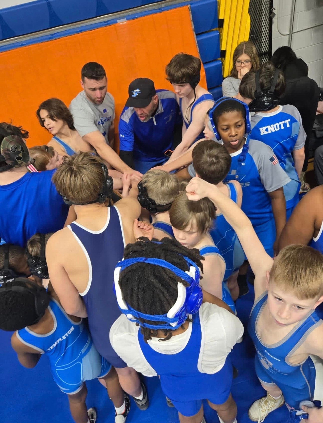 JC Brawlers coach giving instructions to athletes at a tournament